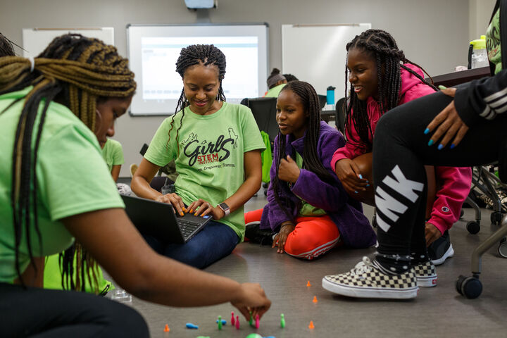 A small group of Black girls conducting a science experiment.